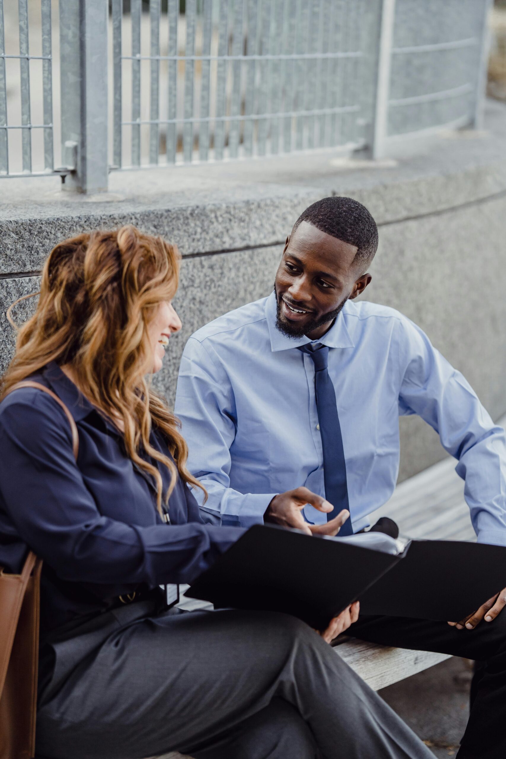 Business Man Smiling at Business Woman showing papers Business Man Smiling at Business Woman showing papers